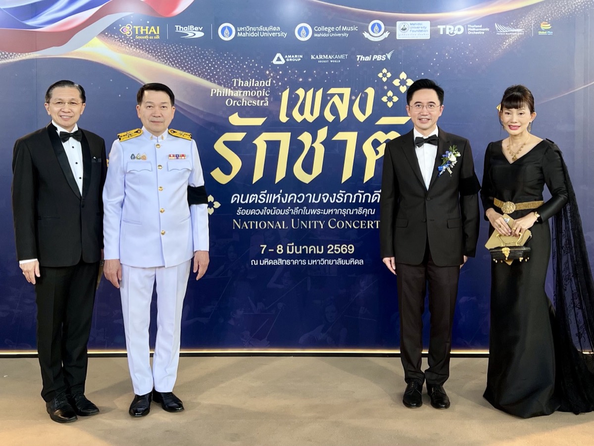 The Board of Directors at the National Unity Concert backdrop, with sponsor logos behind.